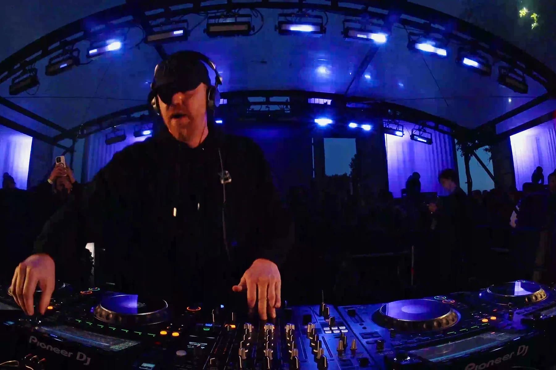 DJ focused on the mixer in purple and blue light