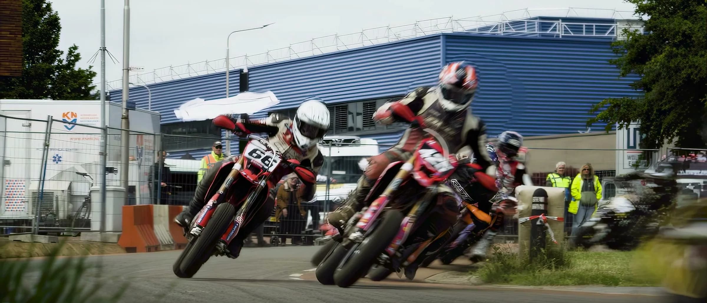 Pack of supermoto riders leaning hard through a street-circuit corner